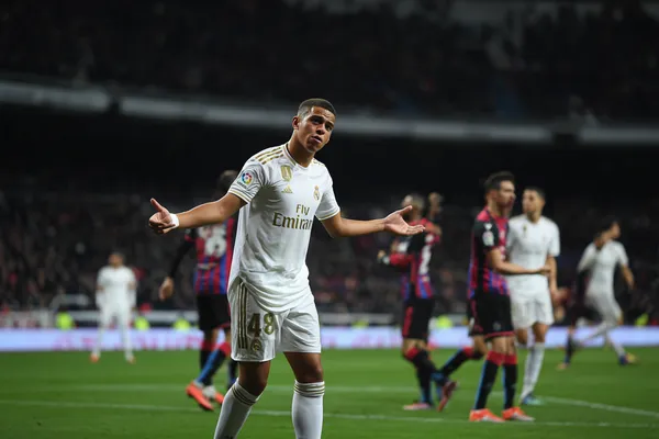 REAL MADRID App - Enjoy seamless gaming on your smartphone A young woman relaxing with her phone while dynamic casino elements float around her, illustrating the smooth mobile experience offered by the REAL MADRID app.