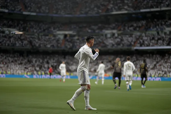 REAL MADRID Mobile App - Your complete hub for casino and sports A man focused on his laptop with live stats in the background, highlighting the dedicated sports and gaming features of the REAL MADRID mobile app.