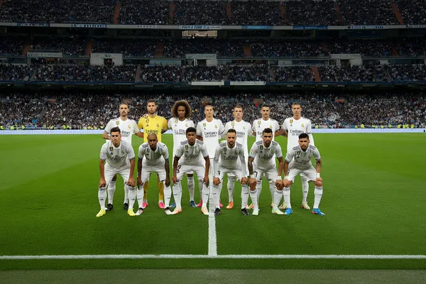 A woman in a luxurious green gown next to an ornate roulette wheel, capturing the upscale casino mood of REAL MADRID.